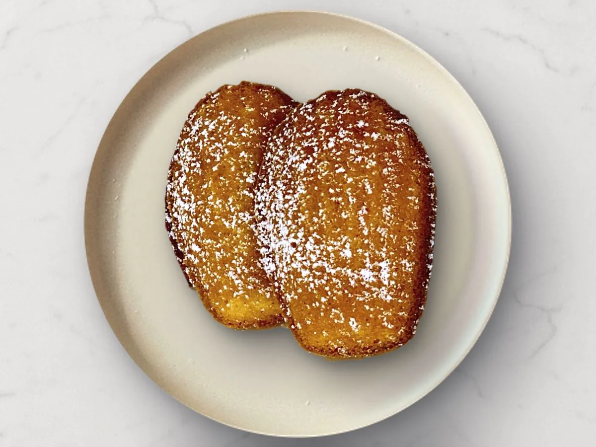 Two Mochi Maddies dusted with powdered sugar on a cream plate