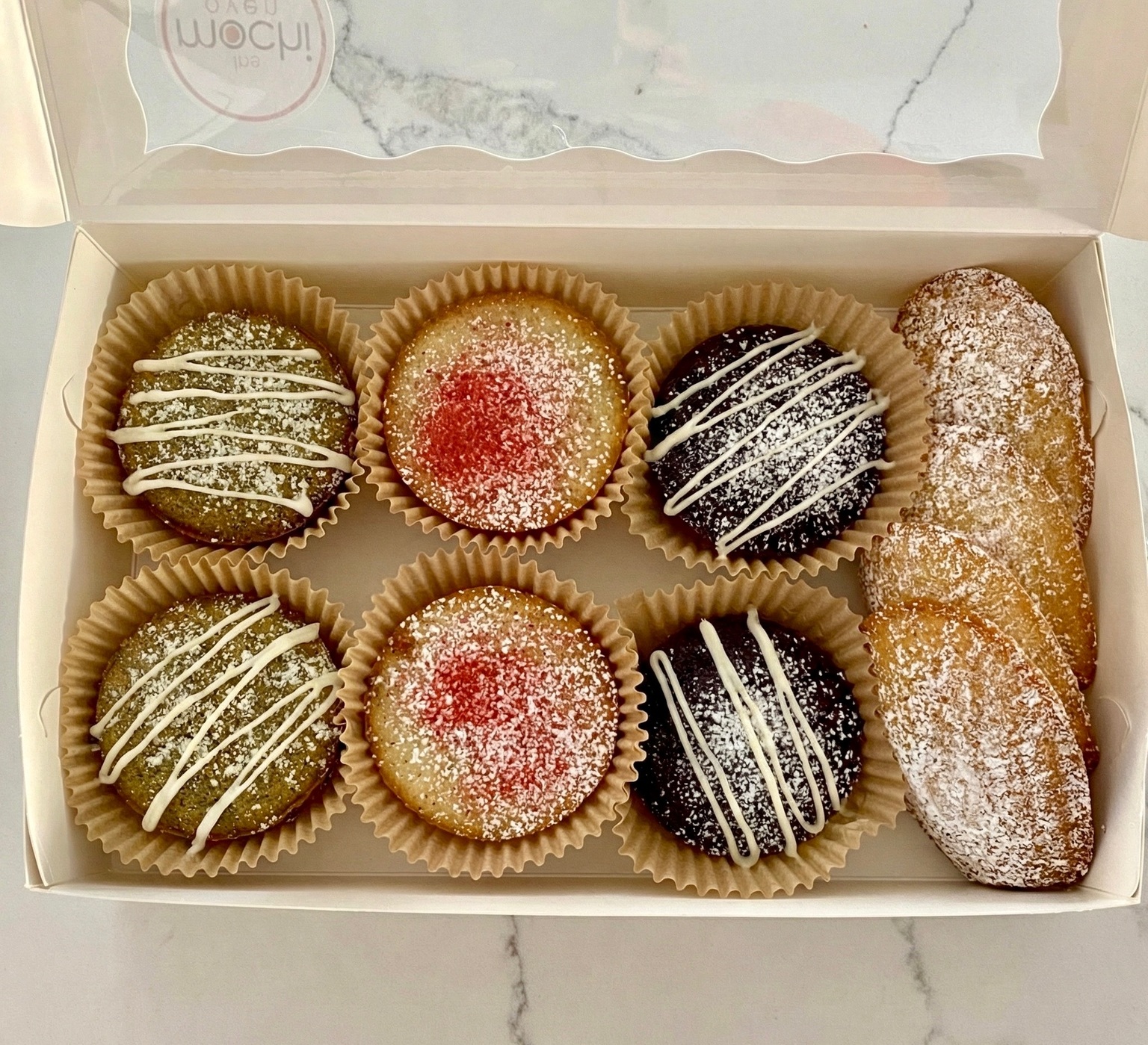 An open box of assorted mochi cakes and Mochi Maddies